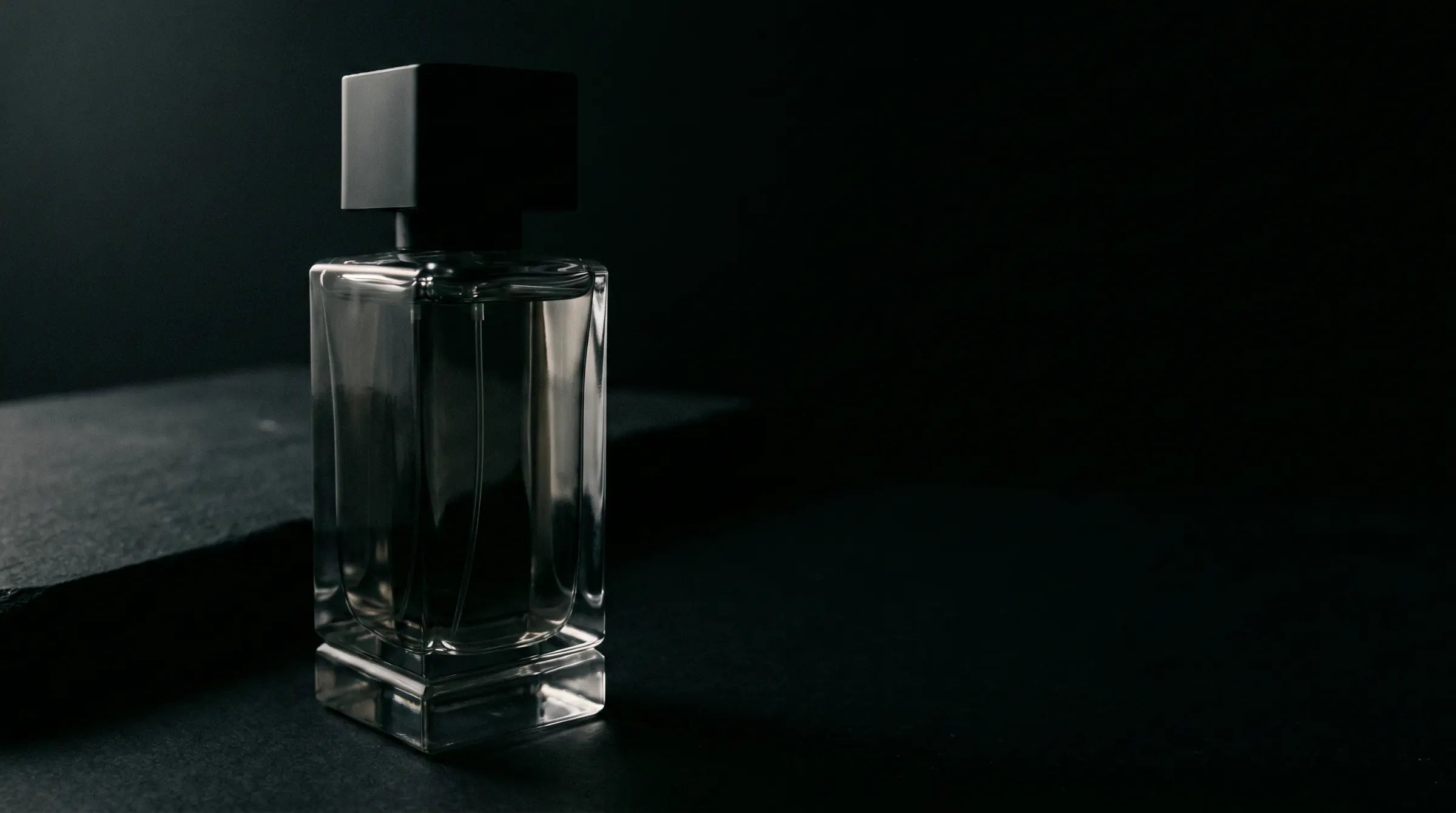 Single bottle, half in shadow, on a dark surface
